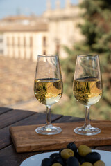 Tasting of Spanish sweet and dry fortified Vino de Jerez sherry wine and olives with view on roofs and houses of old andalusian town