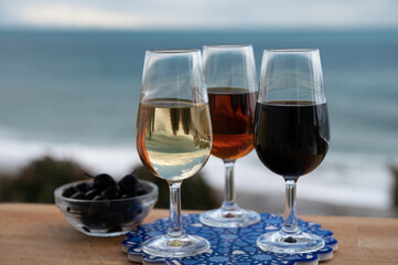 Tasting of Spanish sweet and dry fortified Vino de Jerez sherry wine and green olives with view on blue sea near El Puerto de Santa Maria, Andalusia, Spain