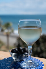 Spanish dry rueda white wine and black olives tapas served on beach terrace with view on Mediterranean sea