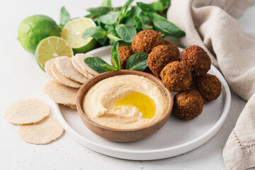 Bowl of fried falafel and hummus dip. Middle Eastern cuisine snack. Close-up view, side view - obrazy, fototapety, plakaty