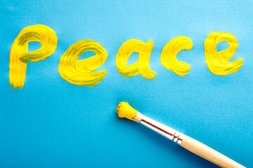 A word PEACE writter in a rough manner on blue paper.