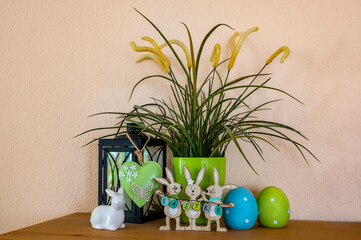 Flowerpot, wooden Easter bunnies with the text Easter on the Easter eggs and other decoration.