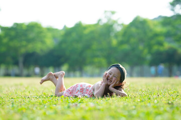 芝生に寝転ぶ笑顔の少女