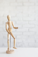 wooden human figure over white brick wall background