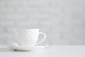 white cup on the white table over white background with copy space