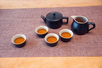 Cup and tea set with tea on table