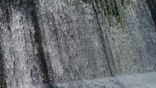 Artificial shaded waterfall on dam on Hirskyi Tikych river, Buky Canyon, Cherkasy Region, Ukraine.
