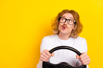 Photo of funny male with interested expression ride auto look empty space dreaming isolated on...