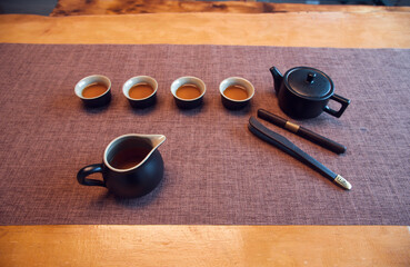 Cup and tea set with tea on table