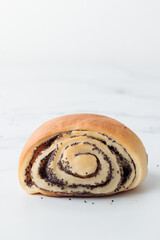 Homemade poppy seed roll buns on a white table