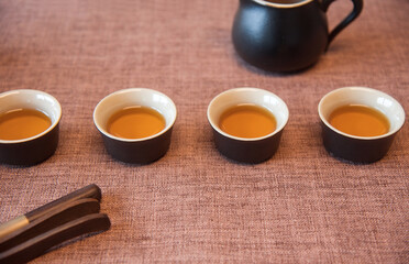Cup and tea set with tea on table