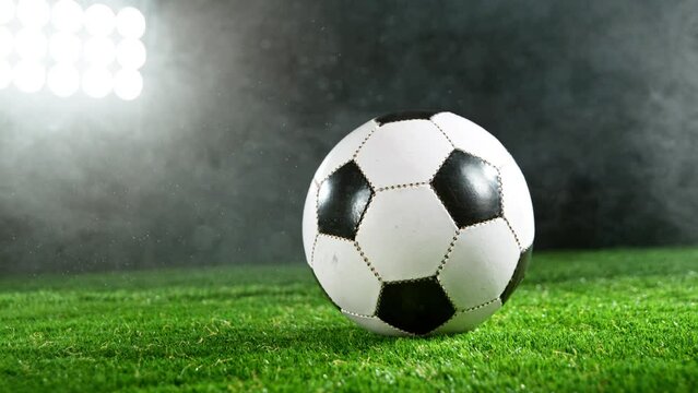 Super slow motion of soccer ball on grass with smoke and rain. Filmed on high speed cinema camera, 1000fps.