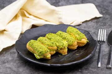 Pistachio eclair cake on dark background. World cuisine delicacies. close up