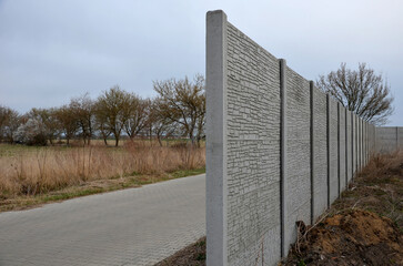 soundproof wall made of concrete porous ribbed material. fence of gray blocks embedded in metal...