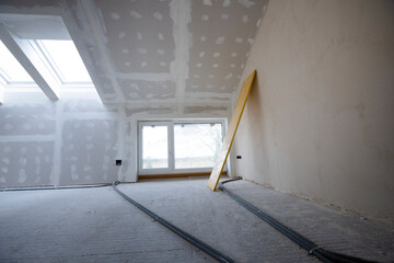 Attic finishing construction site in the phase drywall spackling and plastering before screeding