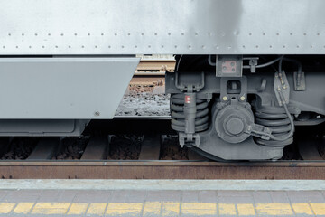 Naklejka na ściany i meble Wheels of a heavy passenger train. Passenger train stands at the platform
