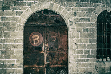 Vintage doors forged and rusty in a stone wall