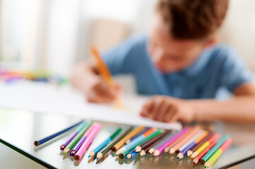 Selective focus. Little schoolboy drawing picture. Back to school. Home schooling and education at home