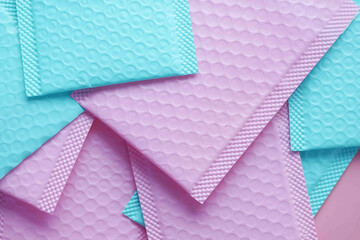  pink and green color paper bubble envelope on table 