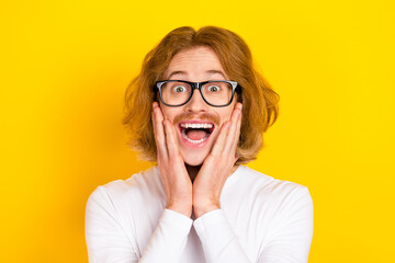 Photo of excited funky guy wear white shirt spectacles arms cheeks isolated yellow color background