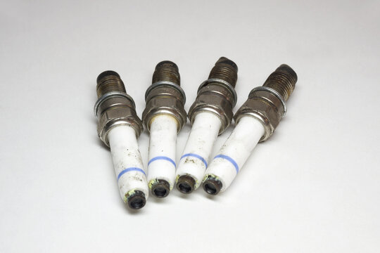 spark plugs kit. old and dirty plugs, white insulator with blue strip