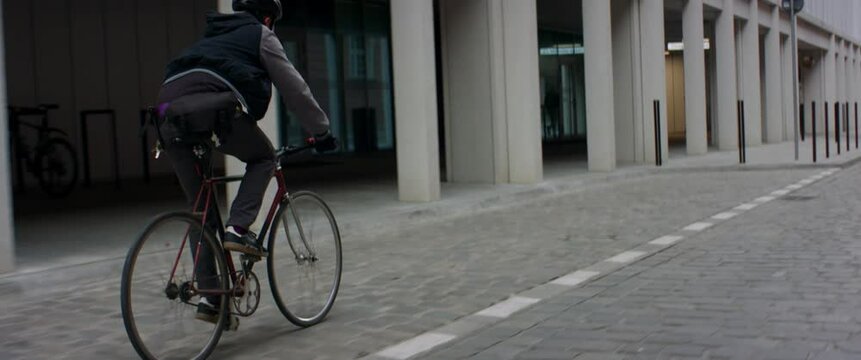 TRACKING Young Caucasian male commuting on his vintage fixed gear bicycle through the city
