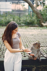 Woman on vacation playing with a monkey