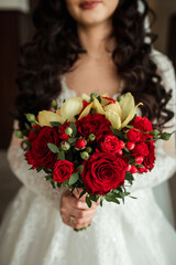 beautiful wedding bouquet of red flowers in the hands of the bride