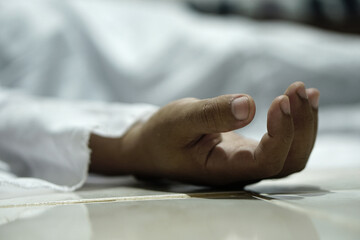 dead body laying on a floor.Focus at the Hand