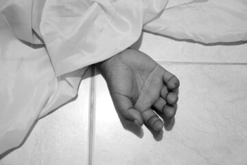 dead body laying on a floor.Focus at the Hand