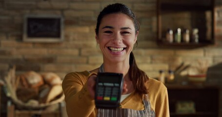 Cinematic shot of young friendly smiling saleswoman showing in camera atm terminal for contactless payments and NFC technology service in bakery shop. - Powered by Adobe