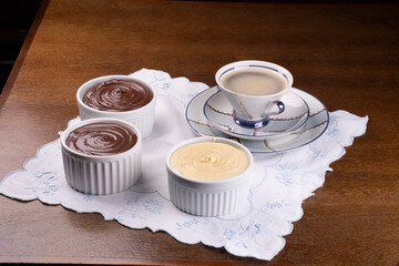 hazelnut, chocolate and white chocolate creams on coffee cup table and angle view