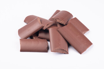 milk chocolate kibbles, pieces angle view close-up isolated on white background