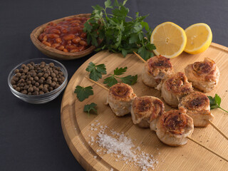 skewers of chicken and bacon on a wooden board.