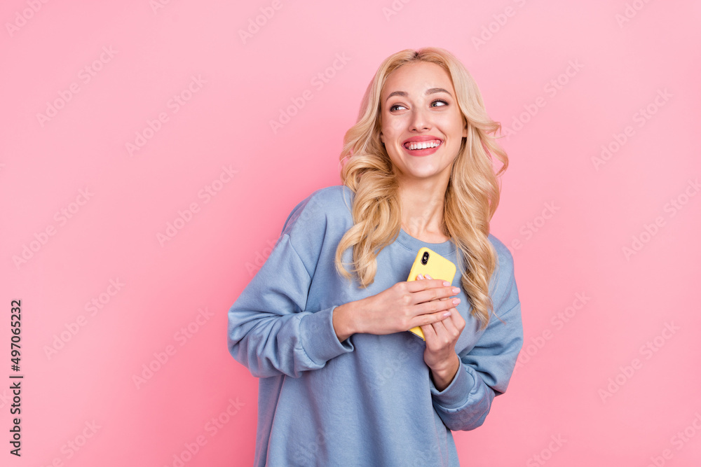 Sticker Photo of young cheerful girl curious look empty space hold mobile dream isolated over pink color background