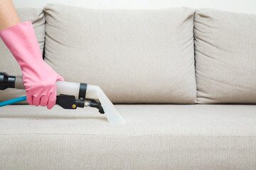 Woman hand in rubber protective glove using spray nozzle of professional vacuum cleaner and washing...