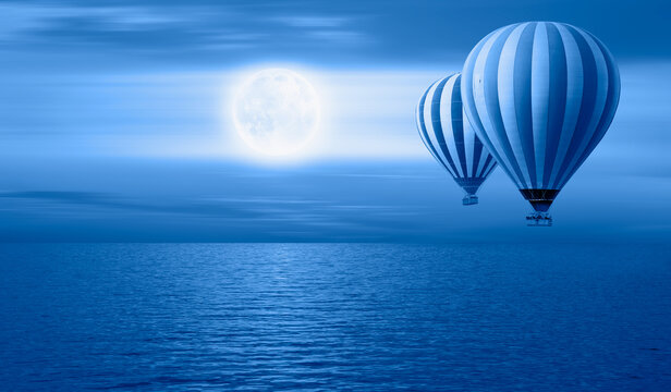 Surreal background - Hot air balloon flying over crescent moon with serene sea in sunset sky  "Elements of this image furnished by NASA"
