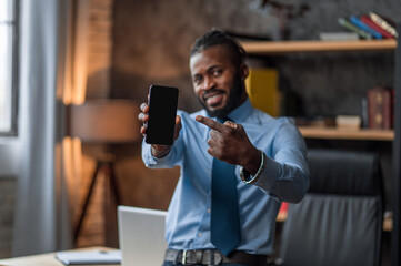 Smiling contented company employee showing off his smartphone