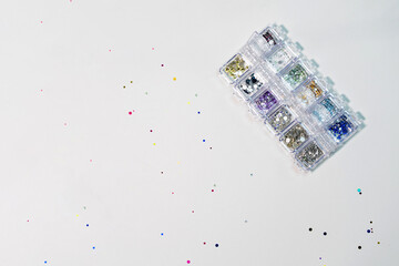 Multi-colored sequins, srazy, pebbles. Manicure design tools.