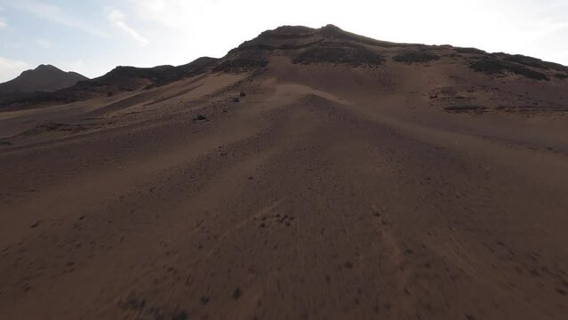 Aerial drone ascending on top mountain near Zagora in Morocco desert. Aerial fpv