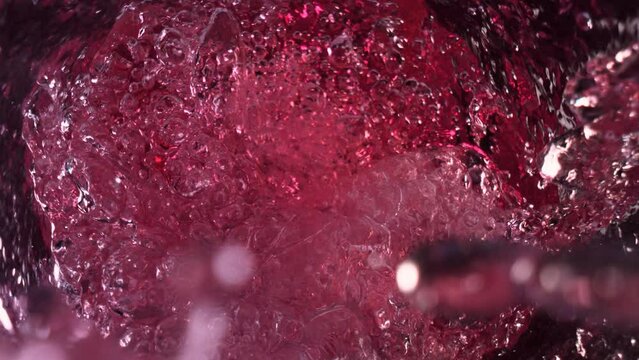 Super Slow Motion Shot of Raspberry Lemonade Whirling and Splashing in Glass Bottle at 1000fps.