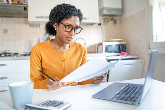 One black young woman calculating home expenses working at home