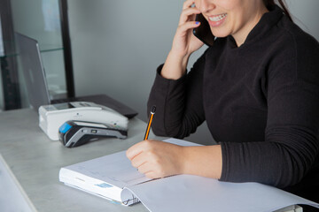 Mujer sonriente apuntando una cita en su cuaderno