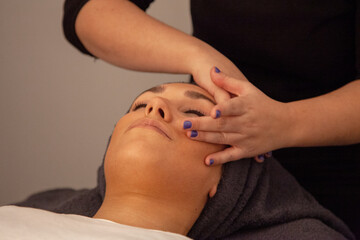 Masaje facial. Mujer recibiendo un masaje en la cara en una clínica de estética