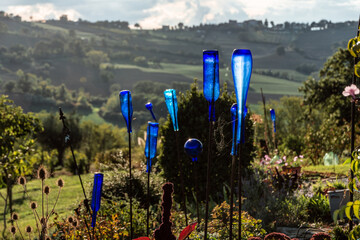 blue glass bottles as garden decoration at sunset