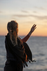 Girl near the water in a poncho like a bird