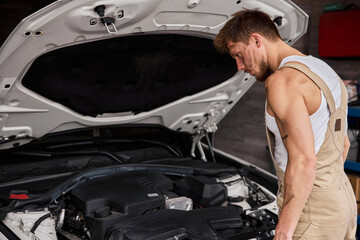 Naklejka na ściany i meble Close Up Shot of a Professional Mechanic Working on Vehicle in Car Service.
