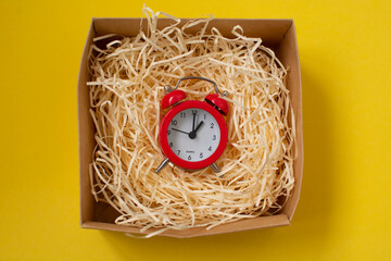 round red alarm clock in wood shavings