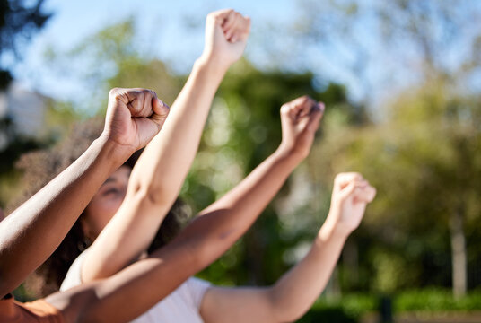Corruption, and injustice wont go away. Shot of an unrecognisable group of women raising their hands in strength outside.
