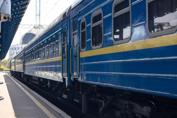 Deurstickers A passenger train with blue carriages stands on a platform. The train departs from the Kiev Railway Station © Klochkov